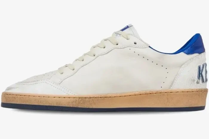 Side profile of Golden Goose Ball Star distressed white sneakers featuring blue heel tabs and a vintage tan midsole. - SKU GMF00117-F002198-10327