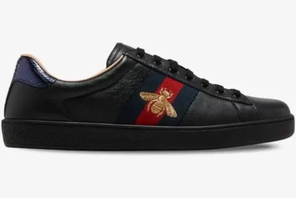 Side view of Gucci Ace Bee black leather sneakers with gold bee embroidery and web stripe. - SKU 42944602JP01284