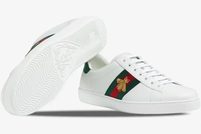 Gucci Ace white leather sneakers featuring gold bee embroidery and a view of the patterned sole. - SKU 42944602JP09064