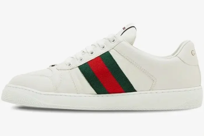 Side profile of white Gucci Ace sneakers with embossed GG leather and signature green and red web stripe. - SKU 798785AADU09094