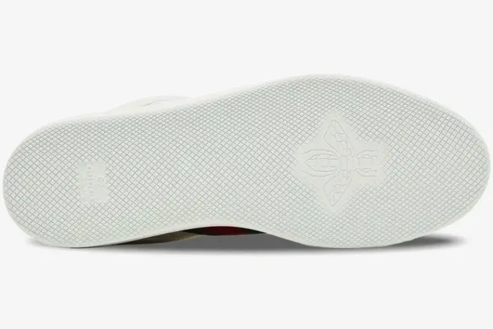 Bottom view of white Gucci Ace sneakers showing the textured rubber sole with an embossed bee logo. - SKU 798785AADU09094