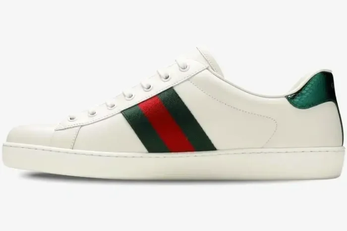 Side view of Gucci Ace white leather sneakers with green and red web stripe and green snakeskin heel tab. - SKU 42944602JP09064