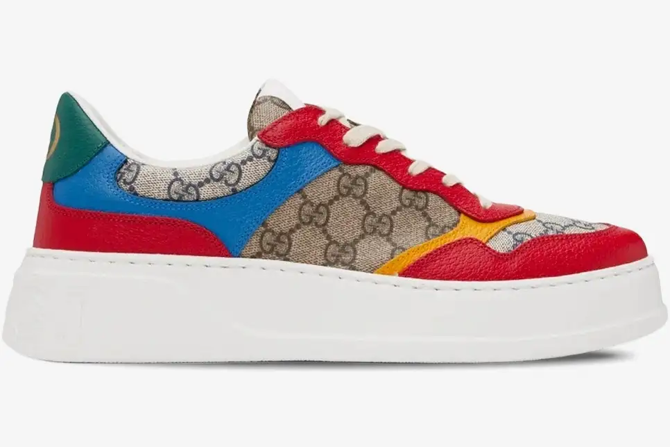 gucci-gg-supreme-low-top-sneakers-beige-blue-side-726828fabav4050-941-076 Side view of Gucci GG Supreme low top sneakers in beige canvas with blue, red, and yellow leather panels. - SKU 726828FABAV4050