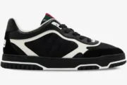 Side profile of a black Gucci Re-Web Sneaker featuring GG canvas, white leather overlays, and a green-red web tongue. - SKU 787476AADHW1077