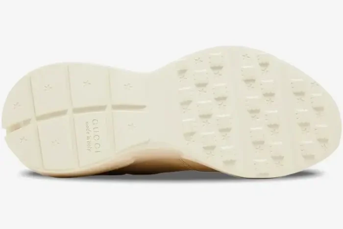Bottom view of the ivory Gucci Rhyton sneaker outsole featuring star patterns and embossed logo. - SKU 757857UPG709567