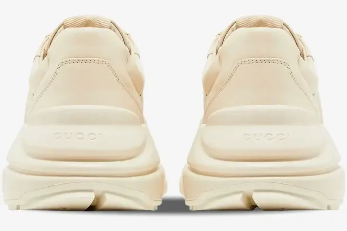 Rear view of ivory Gucci Rhyton sneakers showing the chunky sole and embossed Gucci logo on the heel. - SKU 757857UPG709567