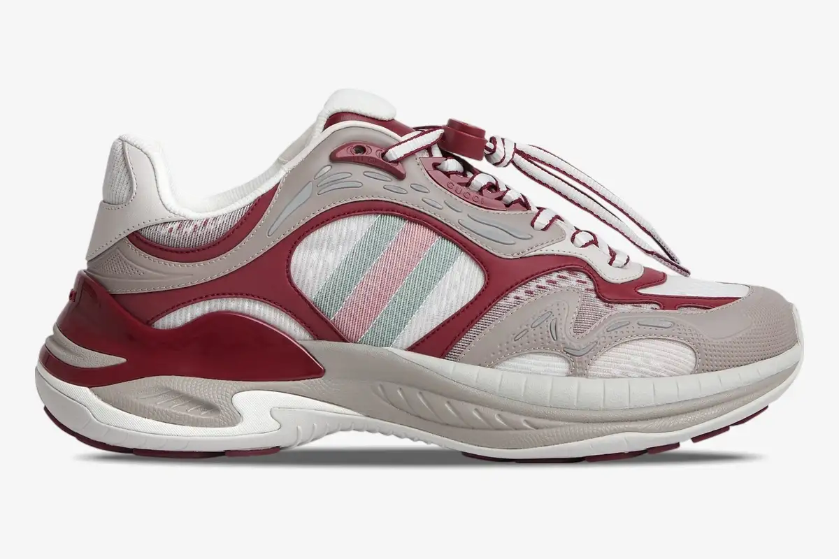 gucci-run-2-0-rosso-ancora-grey-side-view-814040fad5t8754-161-914 Side profile of a Gucci Run 2.0 sneaker in Rosso Ancora and grey mesh with signature stripes. - SKU 814040FAD5T8754
