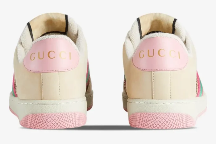 Back view of Gucci Screener GG Supreme distressed sneakers in cream and pink with gold logo on heel. - SKU 548950