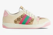 Side view of Gucci Screener GG Supreme distressed sneakers in cream with pink and green web stripe. - SKU 548950