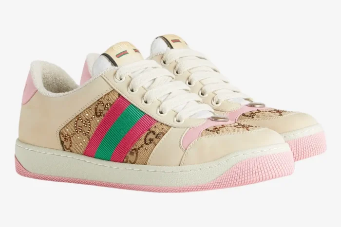 A pair of Gucci Screener GG Supreme distressed sneakers in cream and pink, side three-quarter view. - SKU 548950