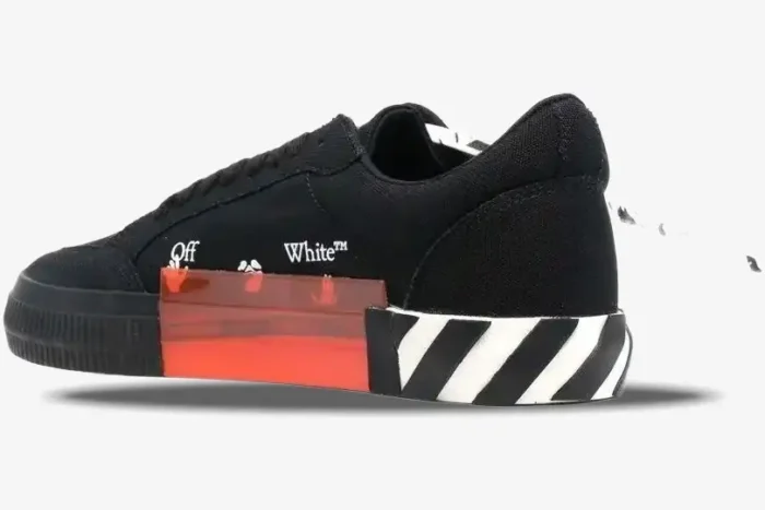 Side profile of Off-White Low Vulcanized black sneakers with orange midsole detail and white stripes. - SKU OWIA272C99LEA0011001