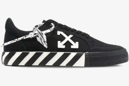 Side view of Off-White Low Vulcanized black canvas sneakers with white arrow logo and striped sole. - SKU OWIA272C99LEA0011001