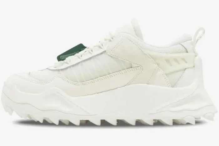 Profile view of an Off-White ODSY-1000 white chunky sneaker with a spiked sole and green zip tie. - SKU OMIA139C99FAB001-0100