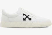 Side view of white Off-White Vulcanized Low Canvas sneakers with a black arrow logo and cream sole. - SKU OMIA085C99FAB0070110