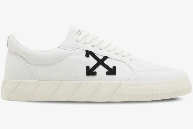 off-white-vulcanized-low-canvas-white-side-view-omia085c99fab0070110-986-362 Side view of white Off-White Vulcanized Low Canvas sneakers with a black arrow logo and cream sole. - SKU OMIA085C99FAB0070110