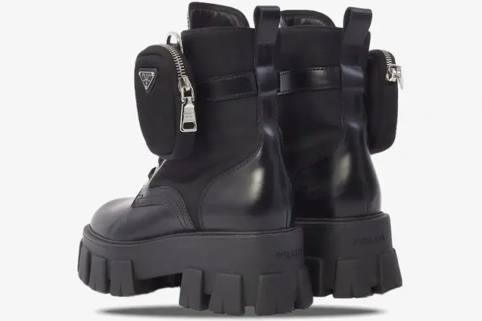 Rear view of black Prada Monolith leather boots with chunky lug soles and detachable nylon pouches. - SKU 1T255M_3L09_F0002_F_055